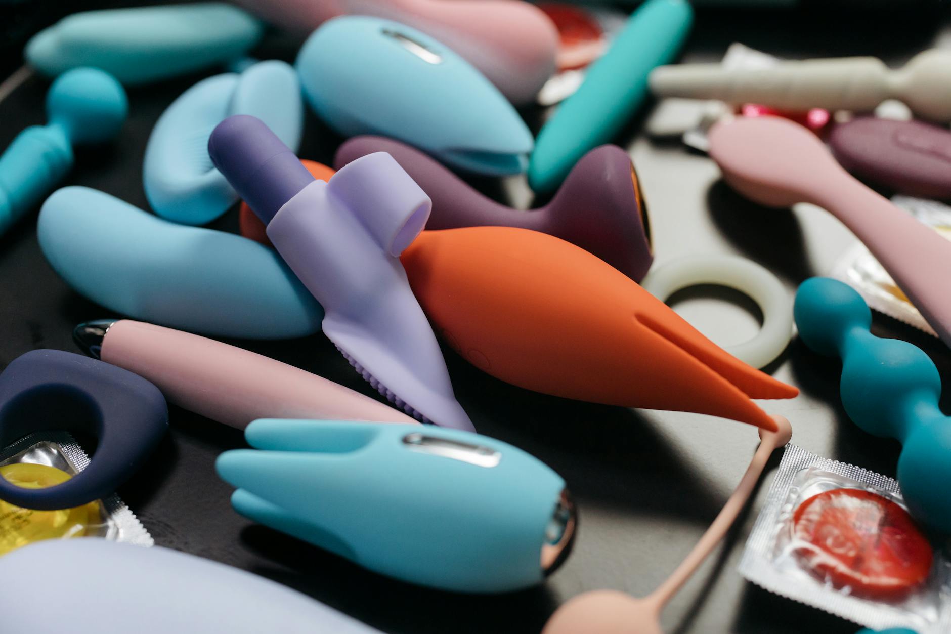 An array of vibrant adult toys including vibrators and rings displayed in close-up view