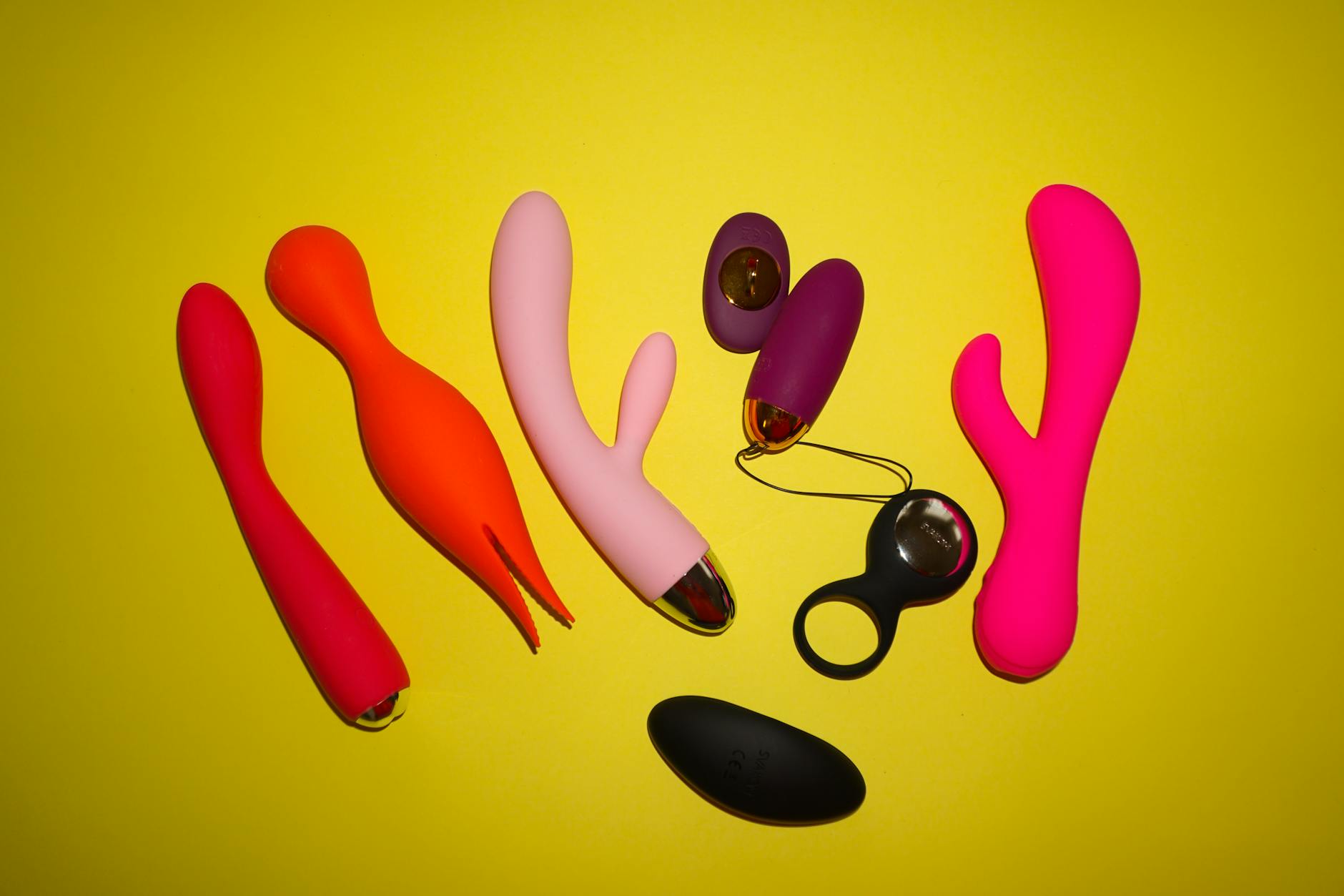 A hand holding an orange vibrator against a purple backdrop, representing sexual wellness and pleasure during medication.