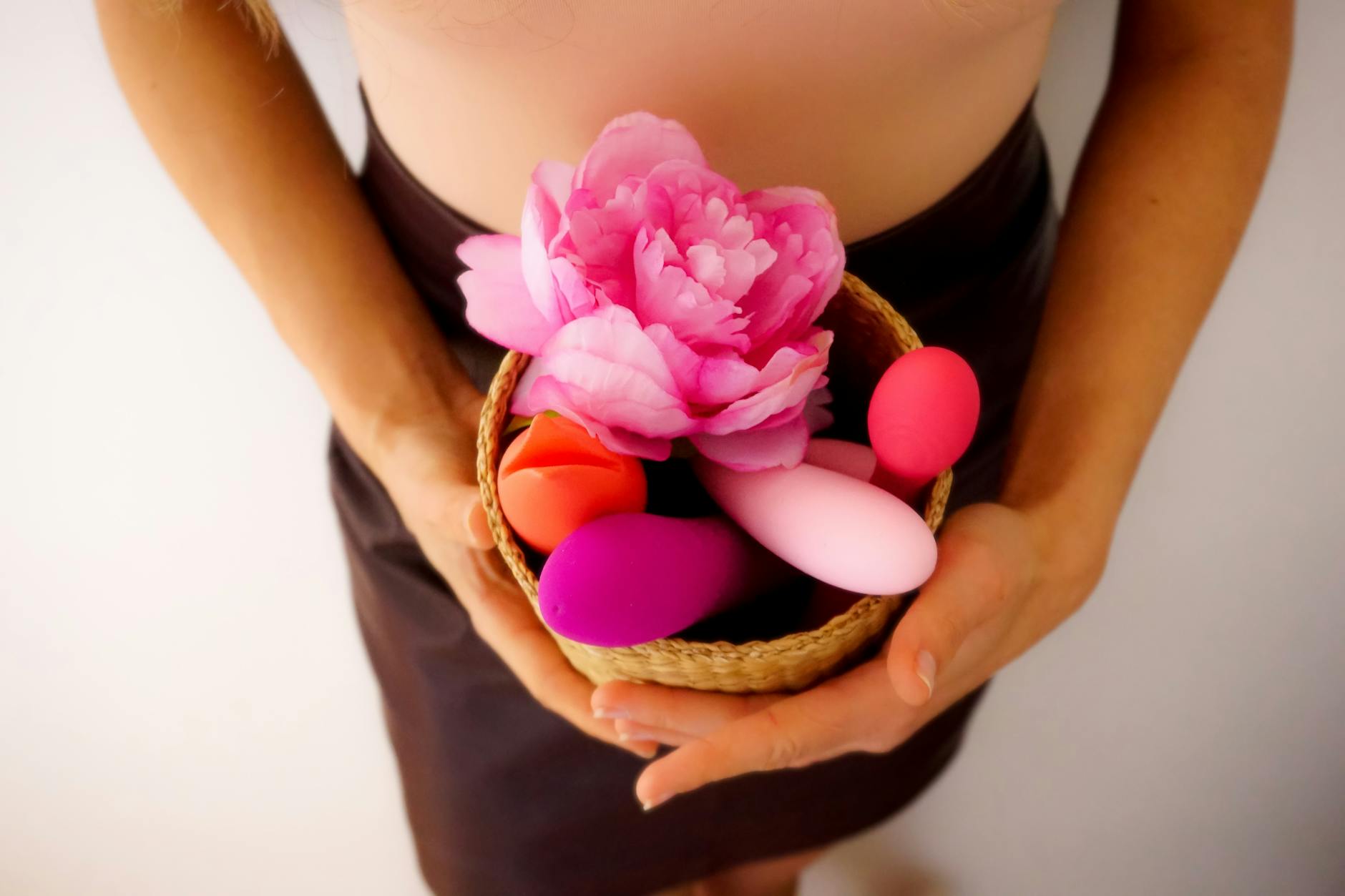 Hand holding a vibrator against a purple backdrop, representing modern clitoral pleasure tools